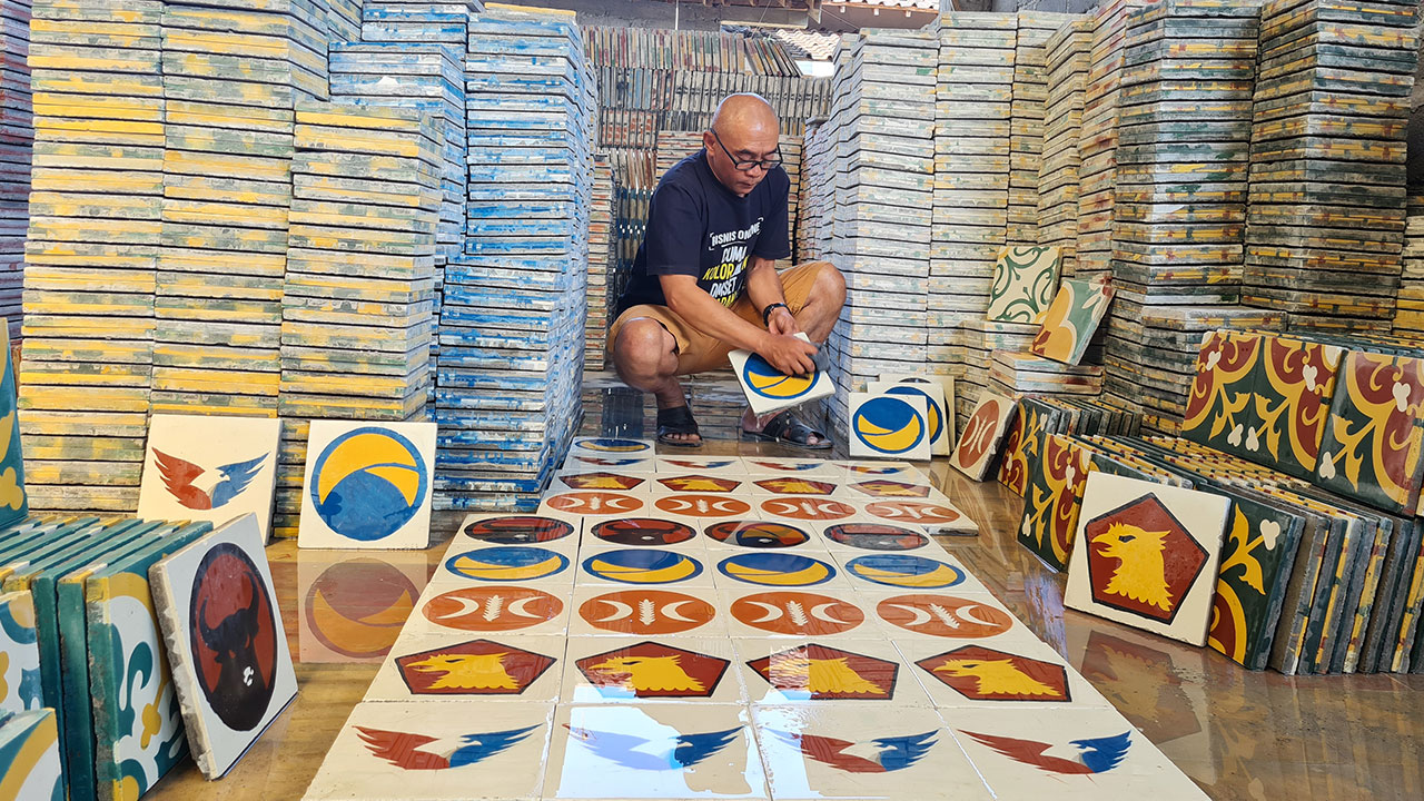 KREATIF: Pekerja tengah menata tegel motif logo partai politik (parpol) di industri pembuatan tegel Win Art Solution, Dusun Ponggol, Tamanagung, Muntilan.(Naila Nihayah/Radar Jogja)