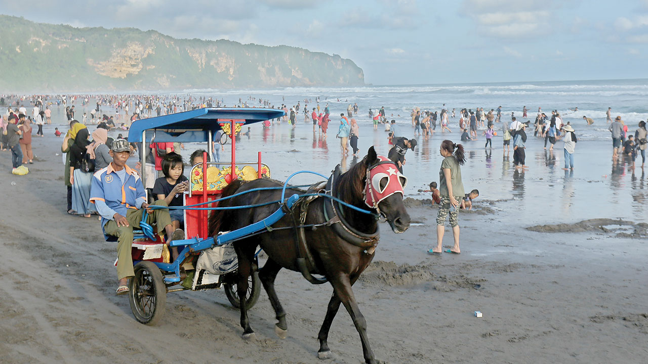 PRIMADONA: Pantai Parangtritis yang ramai dikunjungi wisatawan beberapa waktu lalu. Dinas Pariwisata Bantul mencatat, hampir 80 persen wisatawan yang datang ke Bantul memilih berwisata ke kawasan pantai selatan.(ELANG KHARISMA DEWANGGA/RADAR JOGJA )