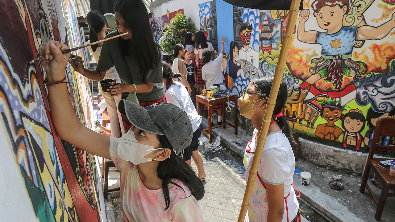 ANTUSIAS: Siswa-siswi SMP Stella Duce 1 Jogja menghias dinding dengan mural di Kampung Dagen, Gedong Tengen, Jogja kemarin (31/5). Kegiatan ini digelar untuk kenang-kenangan siswa kelas IX sebelum lulus.(ELANG KHARISMA DEWANGGA/RADAR JOGJA)