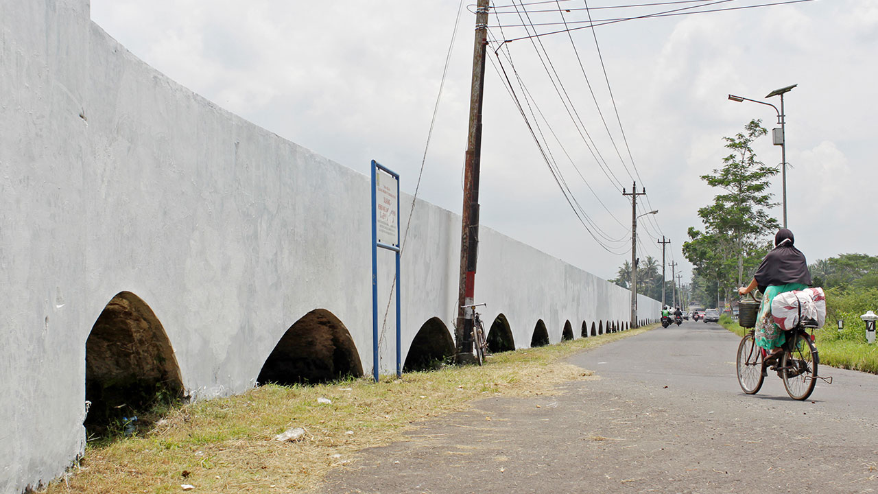 CAGAR BUDAYA: Pesepeda melintas di dekat bangunan cagar budaya Kanal Van Der Wijck atau lebih dikenal dengan Buk Renteng, di Banyurejo, Tempel (31/5).(GUNTUR AGA TIRTANA/RADAR JOGJA )