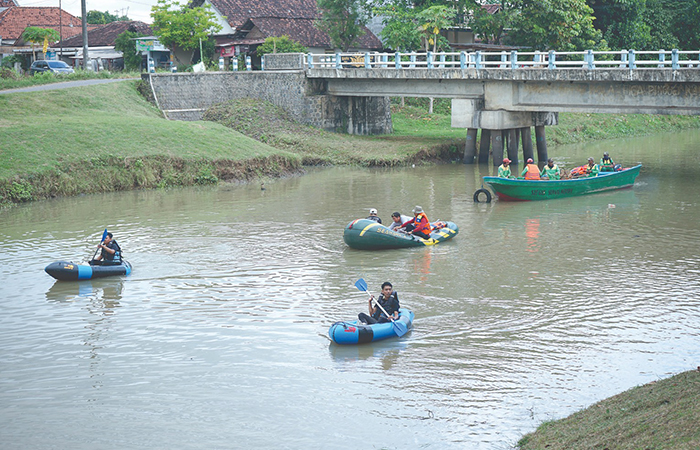 TELUSURI: Komunitas peduli lingkungan dan DLH Tulungagung menyusuri sungai Ngrowo untuk mencari sampah. (Foto : SATRIA CAHYONO/RADAR TULUNGAGUNG)