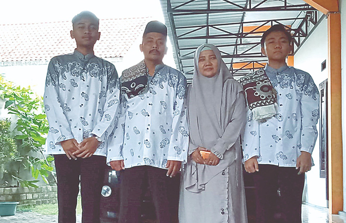 BERTAHAN: Purwoto (tengah) foto bersama dengan keluarganya yang hingga kini masih menikmati hasil dari agen koran Jawa Pos Radar Tulungagung.