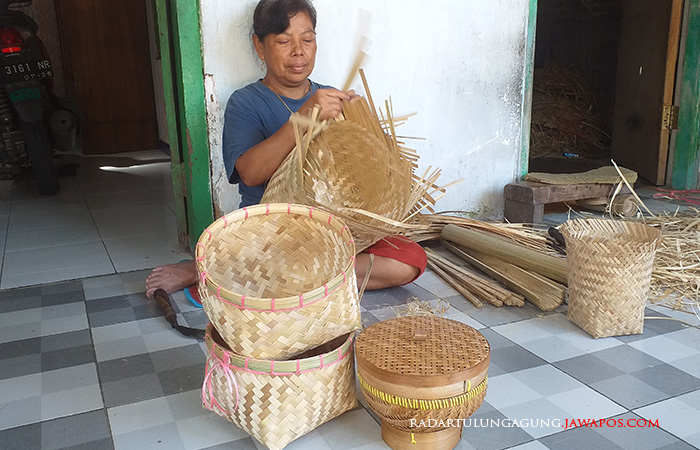 TELATEN: Diah sedang membuat kerajinan anyaman bambu di rumahnya. Anyaman tersebut bisa dibentuk menjadi beberapa benda bernilai guna.&nbsp;