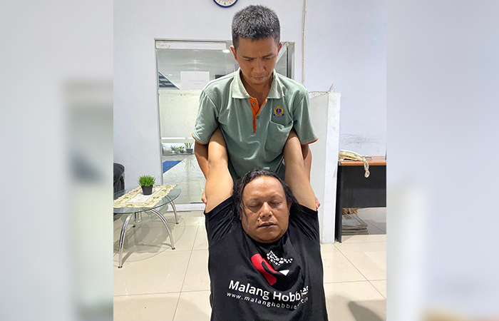 MENAHAN SAKIT: Agus Wahyu Widodo saat menggarap salah satu pasiennya beberapa waktu lalu.