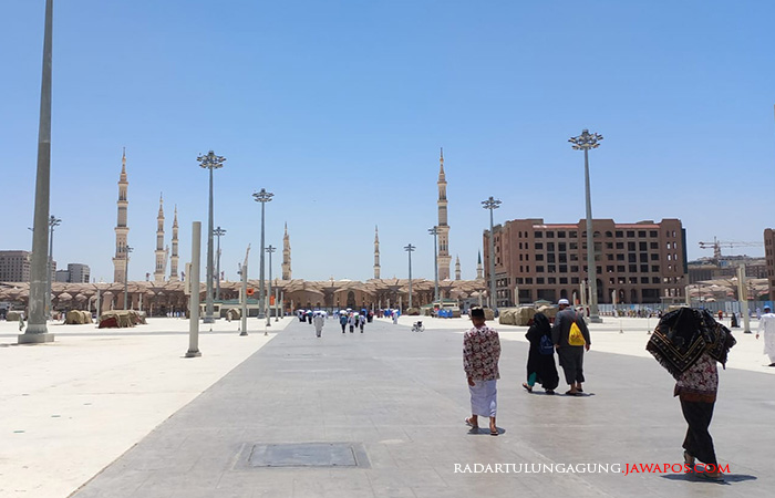 PANAS: Sejumlah jemaah tampak menutupi kepala menggunakan sajadah, berlindung dari cuaca panas di pelataran Masjid Nabawi.