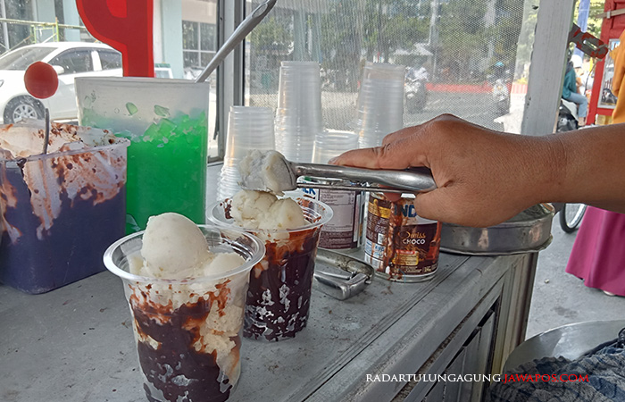 LEGENDARIS: Lilis Astuti menyajikan es tung di tepi Jalan Dr Wahidin, Kelurahan Kepanjenlor, Kecamatan Kepanjenkidul, kemarin (23/6).