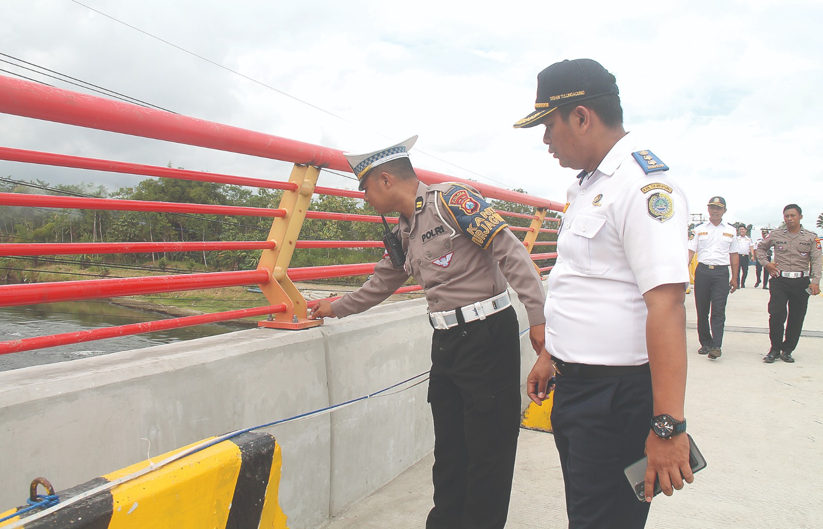 MEMASTIKAN: Polisi dan dishub mengecek pagar jembatan sisi timur untuk keamanan pengendara. (Foto : FAJAR RAHMAD ALI WARDANA/RADAR TULUNGAGUNG)