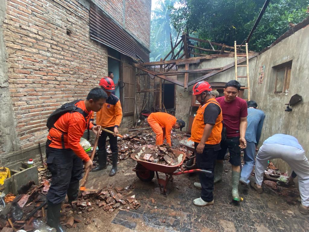 JANGAN PANIK : Petugas gabungan ketika melakukan kerja bakti di rumah milik Lilik, di wilayah Desa Wonoanti, yang rusak akibat gempa di Bantul, DIY.