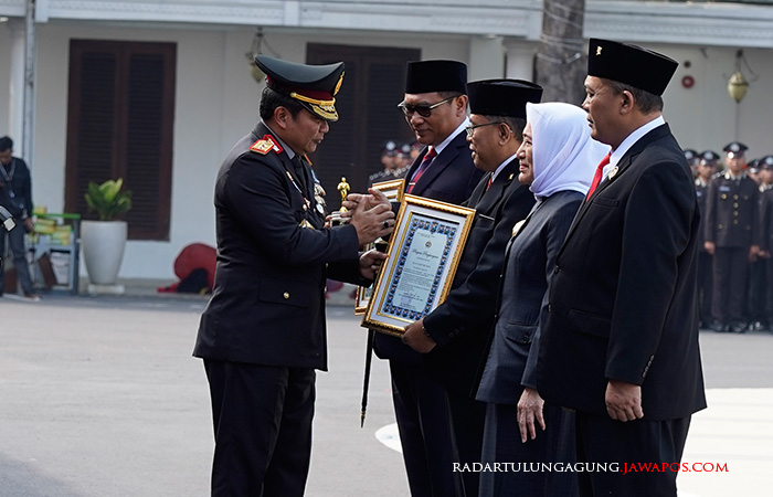 BANGGA: Wali Kota Blitar Santoso menerima penghargaan dari Kapolda Jatim Irjen Toni Harmanto saat upacara peringatan HUT Bhayangkara ke-77 di Surabaya, Sabtu (1/7).