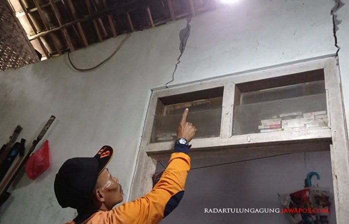RETAK: Personel URC BPBD Kabupaten Blitar Sunar menunjukkan retakan salah satu dinding rumah milik warga Desa Plumbangan, Kecamatan Doko, akibat gempa bumi yang berpusat di Kabupaten Bantul.