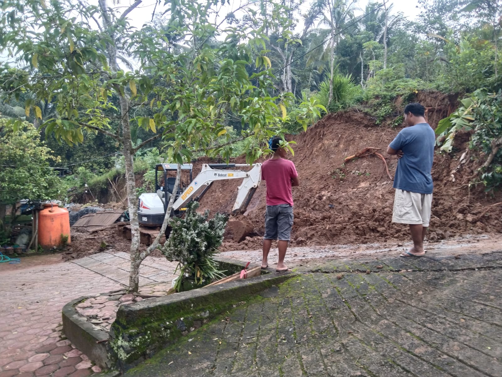 LANGSUNG DIATASI : Warga bersama relawan melakukan pembersihan material longsor yang menutup jalan