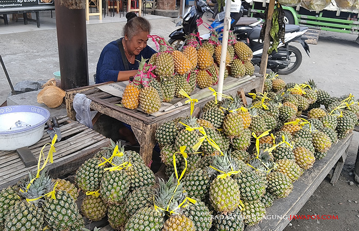 MANIS ASAM: Sutiah sedang menunggu pembeli mampir dan membeli nanas dagangannya kemarin (18/7).&nbsp;