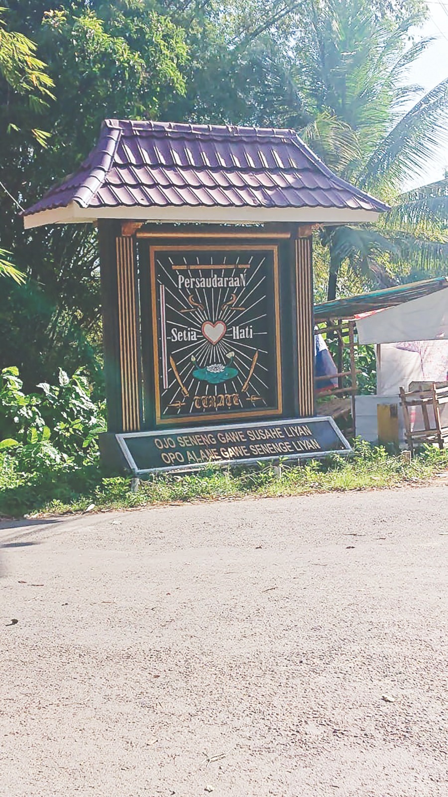 KOKOH : Salah satu tugu PSHT yang berdiri di tepi jalan raya.