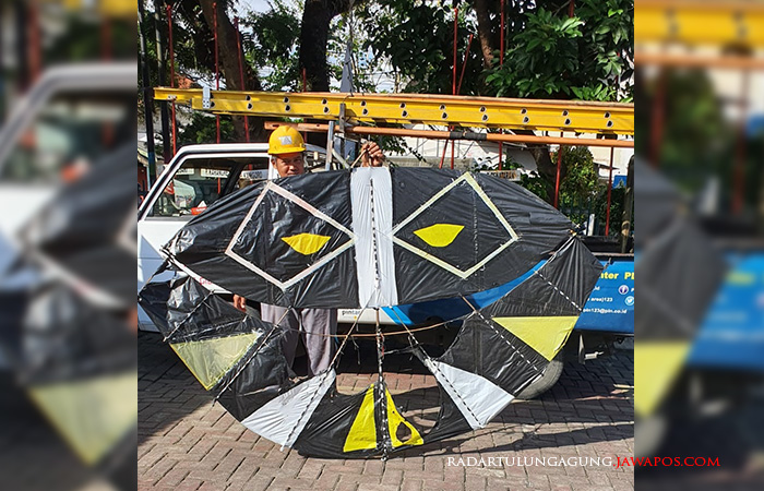 BERBAHAYA: Petugas PLN menunjukkan layangan gapangan yang putus dan tersangkut di jaringan kabel listrik beberapa hari lalu.
