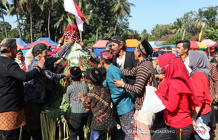 PERDANA: Warga Desa Kemloko, Kecamatan Nglegok, berebut tumpeng hasil bumi saat kirab budaya di lapangan desa.