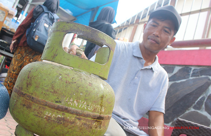 HAMPIR PULIH: Pedagang sedang memeriksa tabung elpiji miliknya. Kini pertamina sudah menambah jumlah pasokan elpiji 3 kg di Blitar Raya.