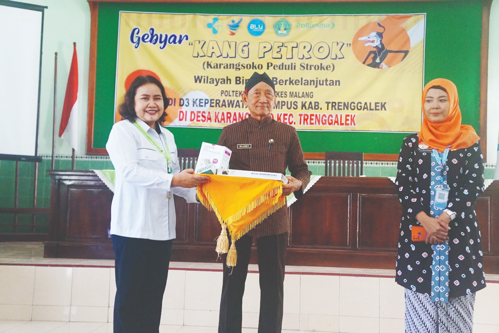 GUNAKAN SEBAIKNYA : Penanggung Jawab Laboratorium Polkesma Prodiga Mimik Christiani, SST, MKes (kiri) memberikan alkes secara simbolis kepada Kades Karangsoko Slamet yang disaksikan K