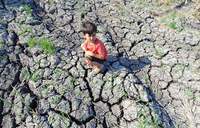 KEMARAU: Anak  kecil bermain di area  persawahan di Desa  Wajak, Kecamatan  Boyolangu yang  kering.