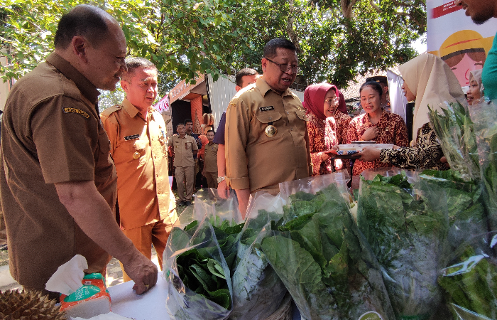 TERTARIK: Bupati Tulungagung Maryoto Birowo (kanan) didampingi Kepala Dinas Ketahanan Pangan  Agus Suswantoro (kiri) saat  mengunjungi stan bazar.