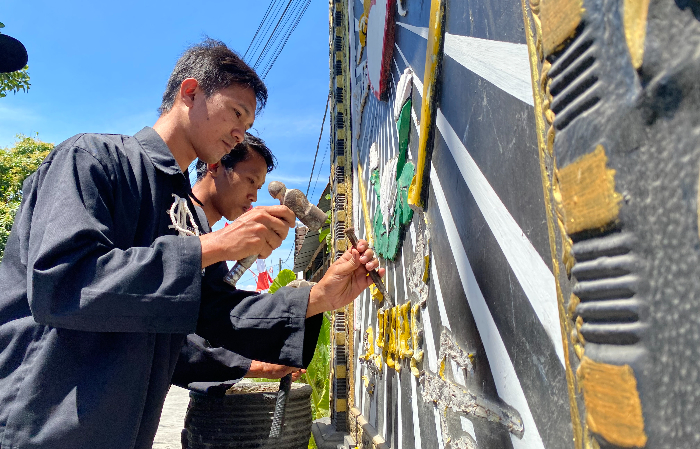 MERELAKAN: Pendekar silat PSHT pada saat memalu ukiran dari logo PSHT di Desa Sobontoro, Kecamatan Boyolangu pada Senin (14/8).