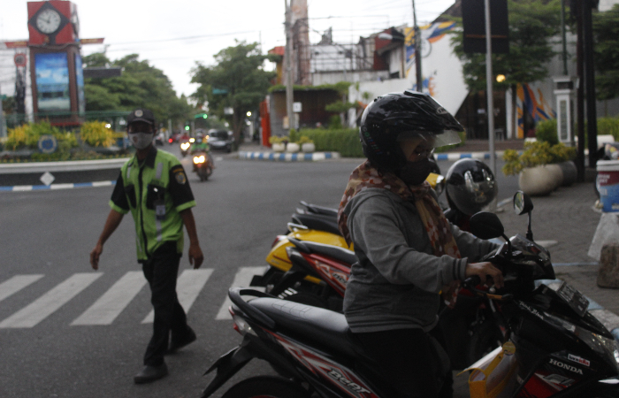 BERDAMPAK: Seorang tukang parkir mengarahkan pengguna sepeda  motor di area bisnis perkotaan Tulungagung. Hilangnya skema parkir  berlangganan bisa mengancam salah satu sumber PAD.