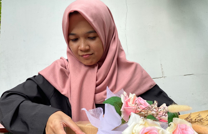 CERMAT: Aprilia Trianingsih sedang menyusun bunga palsu untuk dijadikan buket bunga.