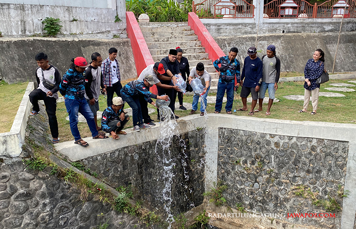 PEDULI: Romy Soekarno dan Komunitas Blitar Micro Fishing saat menebar bibit ikan air tawar di sungai simpang tiga herlingga, Rabu (23/8).