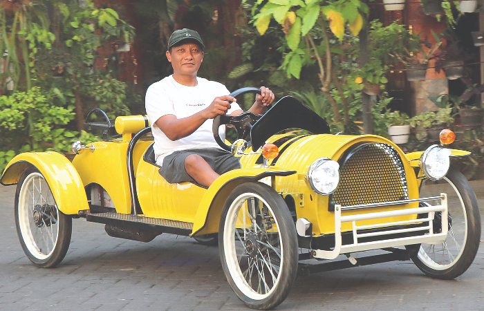 KREATIF: Yudianto saat menaiki mobil berbahan drum bekas hasil karyanya.