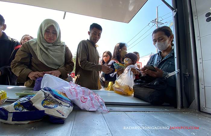 ANTUSIAS : Petugas menyalurkan beras kepada antrean pembeli di gerakan pangan murah, kemarin (30/8).