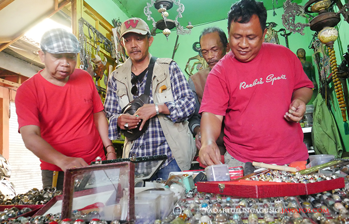RUKUN: Supik sedang melayani pengunjung yang melihat-lihat akik koleksinya kemarin (31/8).