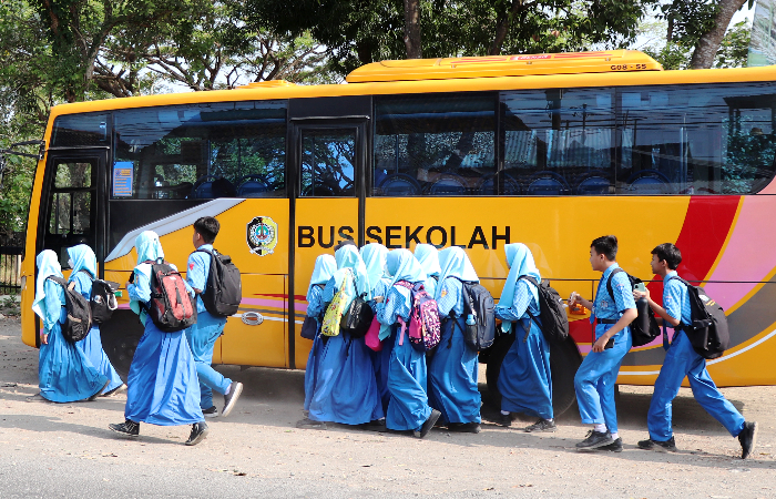 BERGEGAS: Siswa-siswi MTsN  1 Tulungagung saat hendak  menaiki bus sekolah.