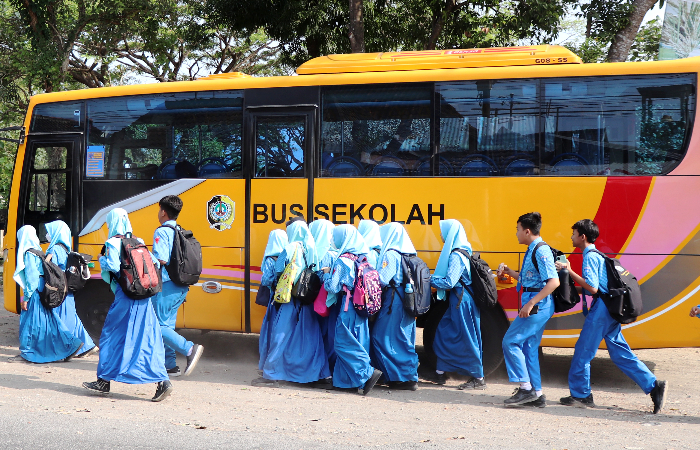 Siswa-siswi yang hendak menaiki bus sekolah.