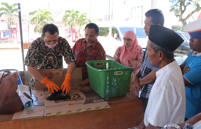PRAKTIK  LANGSUNG:  Petugas dari  Unair Surabaya (baju  merah) saat  memperlihatkan  media  pembuatan  kompos,  Sabtu (9/9).