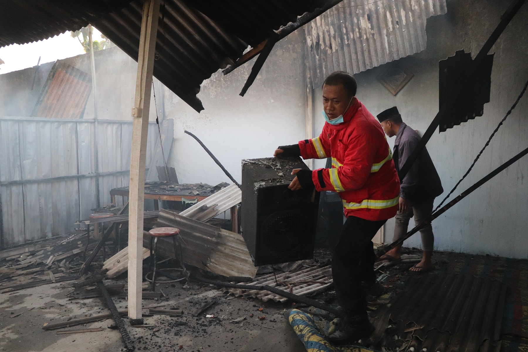 GERAK CEPAT: Petugas Damkar Tulungagung berusaha memadamkan api dan mengevakuasi barang dari kantin UIN SATU yang terbakar.