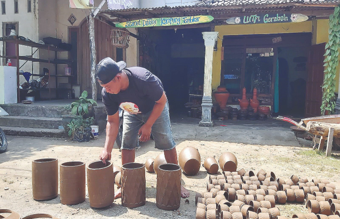 SIBUK: Seorang perajin Desa Plumpungrejo, Kademangan, Kabupaten Blitar, sedang menjemur hasil kerajinanya di bawah terik sinar matahari Minggu (17/9/2023).