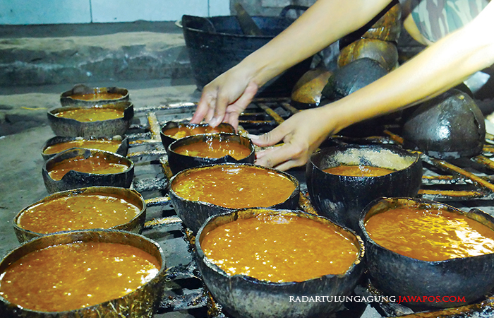 MANIS: Seorang pekerja yang sedang mencetak gula aren dengan batok kelapa