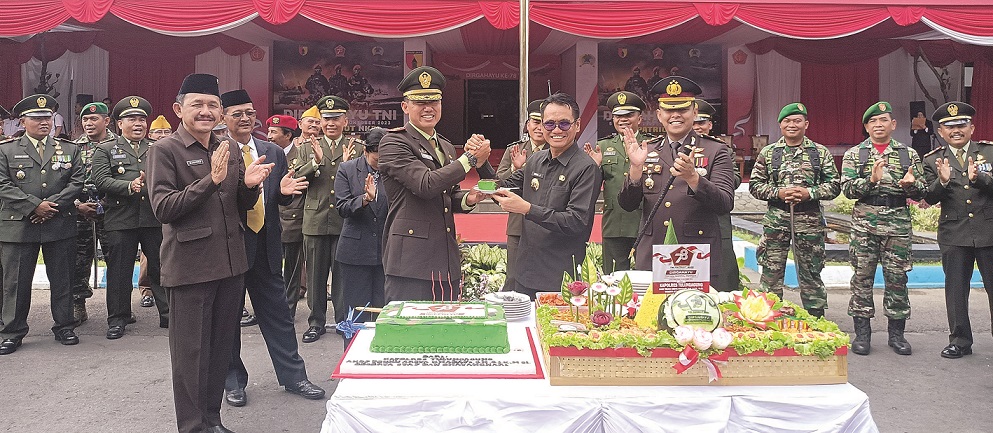 KAWAL INDONESIA MAJU: Pj Bupati Tulungagung Heru Suseno menerima potongan kue dari Dandim 0807 Tulungagung Letkol Czi Nooris Agus Rinanto. (Foto: Prokopim Tulungagung)