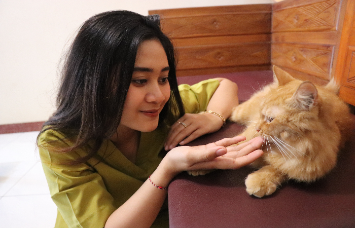 ASYIK: Nisa Rahma Deasury ketika bermain dengan kucingnya bernama Selen.