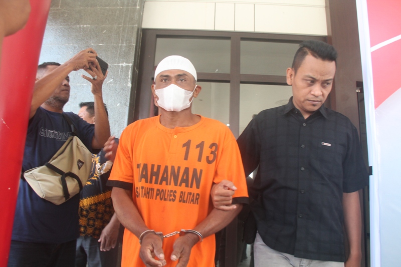 GELAP MATA: Tersangka AS digiring menuju meja rilis Polres Blitar, Jumat (27/10/2023).