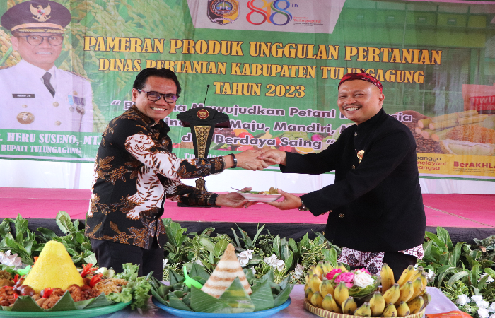 SEMOGA LANCAR: Pj Bupati Tulungagung Heru Suseno (kiri) menyerahkan potongan nasi tumpeng ke Kepala Disperta Suyanto di halaman dinas pertanian, Kamis (2/11/2023).