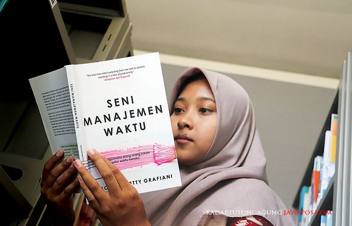 ERLUAS WAWASAN: Seorang mahasiswa asyik membaca salah satu koleksi buku di Perpustakaan Dinperpusip Kota Blitar, Kamis (2/11/2023).