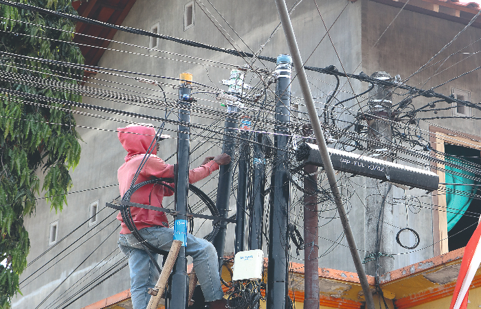 SEMRAWUT: Petugas ketika memasang kabel  telepon di Kelurahan, Panggungrejo, Kecamatan/Kabupaten Tulungagung.