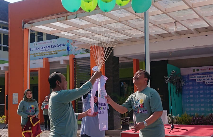 SEDERHANA TAPI KHIDMAT: Direktur RSUD dr Soedomo Trenggalek dr. Mokh. Rofiq Hindiono MMRS didampingi dokter spesialis saraf dr Rosari Listiana menerbangkan balon saat memperingati HKN ke-59 dan WSD.