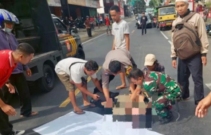 KURANG HATI-HATI: Petugas dan warga mengevakuasi pengendara sepeda motor yang terlibat kecelakaan, Senin (20/11/2023).