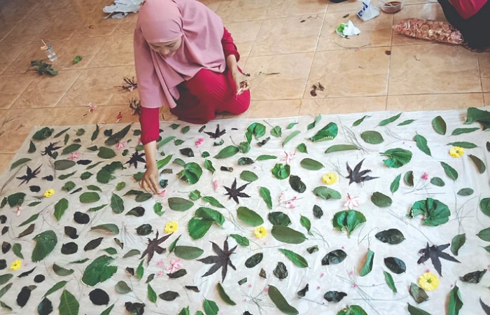 KREATIF: Ary Masithoh Karimah menata daun sebagai motif ecoprint sebelum dikukus.