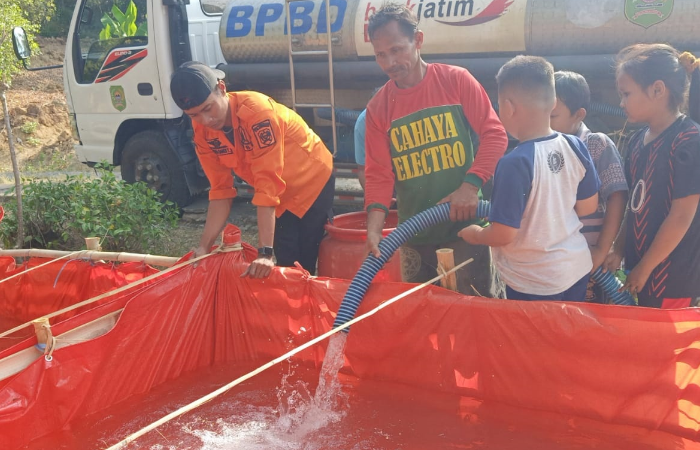 TERUS KIRIM: Petugas BPBD Trenggalek melaksanakan pendistribusian air bersih di salah satu desa yang mengalami kekeringan di Kabupaten Trenggalek.