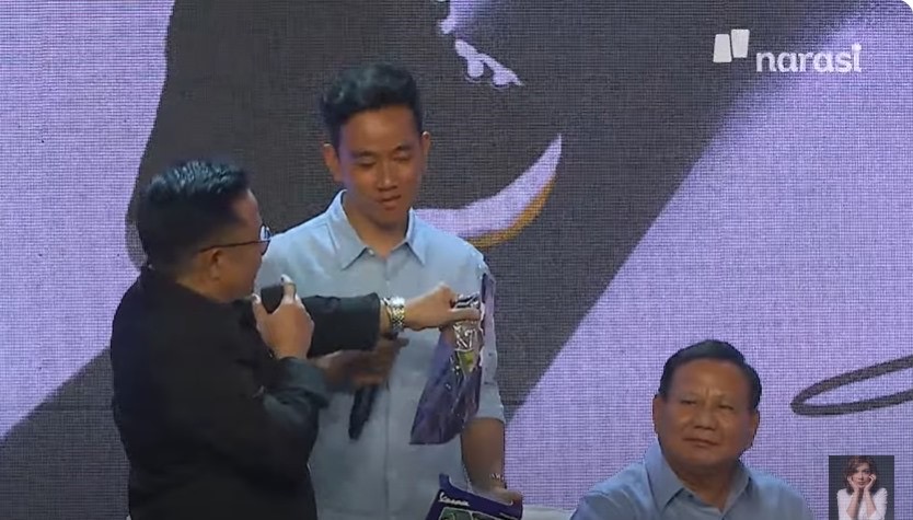Tangkapan layar Narasi TV saat Gibran Rakabuming Raka mendapat kado dari Muhaimin Iskandar di acara Mata Najwa.