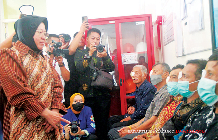 Perhatian : Menteri Sosial Tri Rismaharini berbincang dengan pasien usai operasi katarak massal.