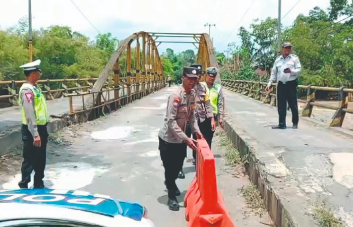 Satlantas Polres Trenggalek menyingkirkan water barrier agar pengguna jalan bisa melintas jembatan Plengkung Trenggalek.