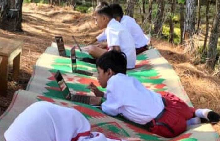 Foto ilustrasi sejumlah siswa mengerjakan tugas di luar sekolah untuk mencari sinyal telekomunikasi.